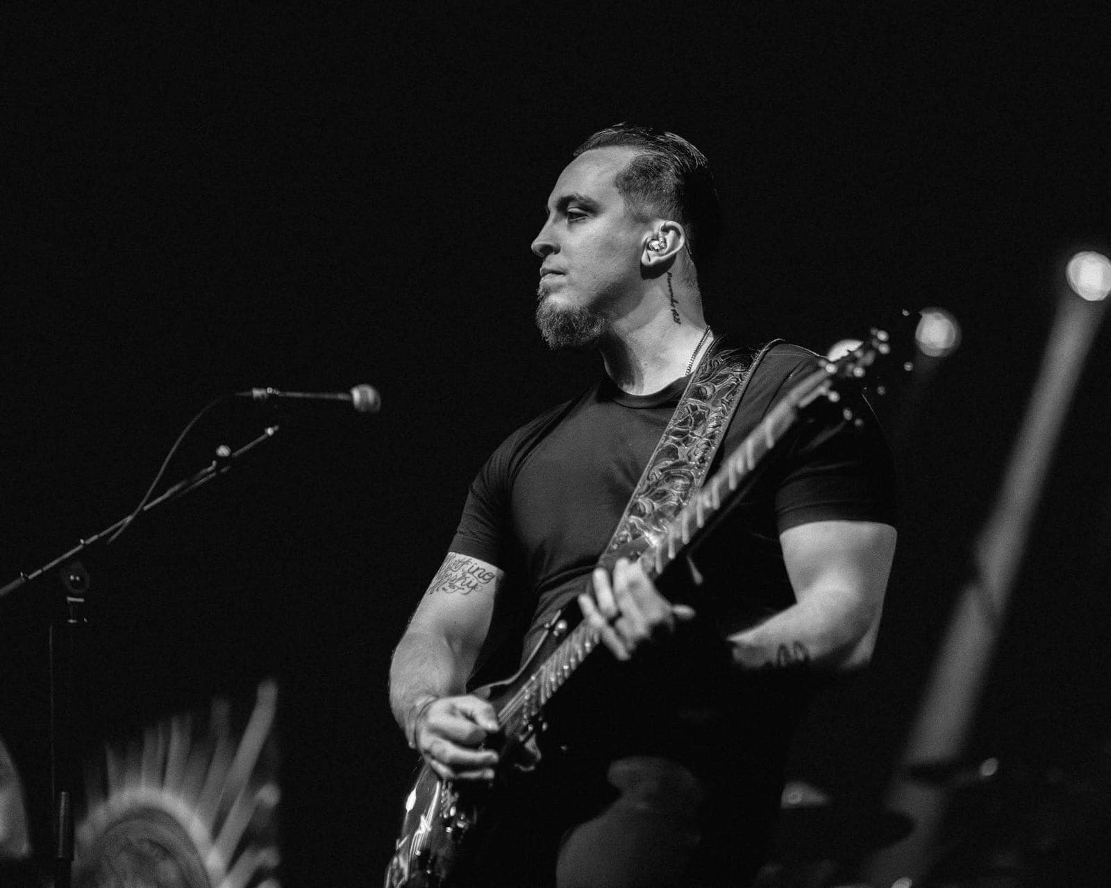 Abel Livas playing guitar on stage, in black and white